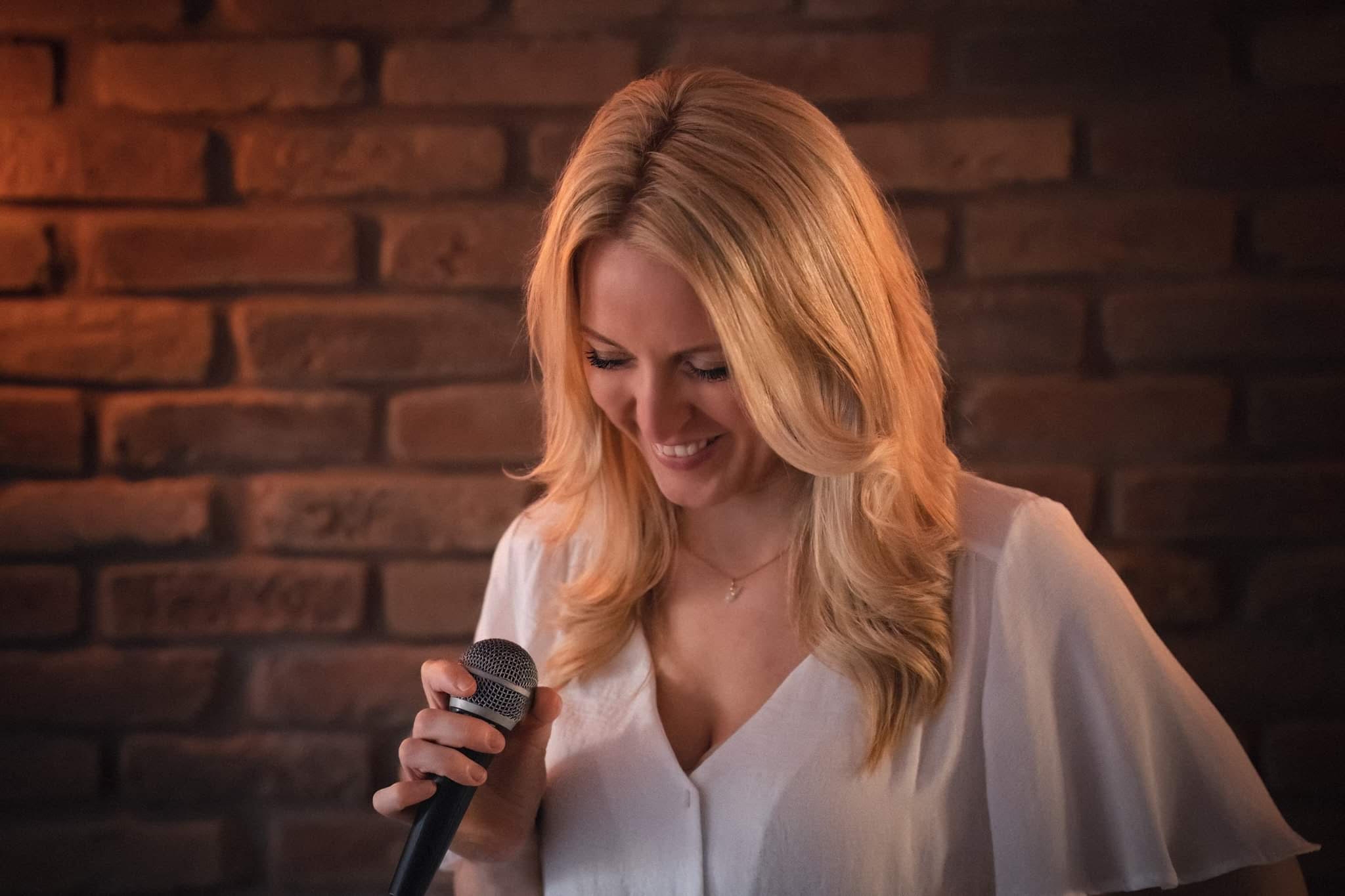 Eliza holding mic promo image